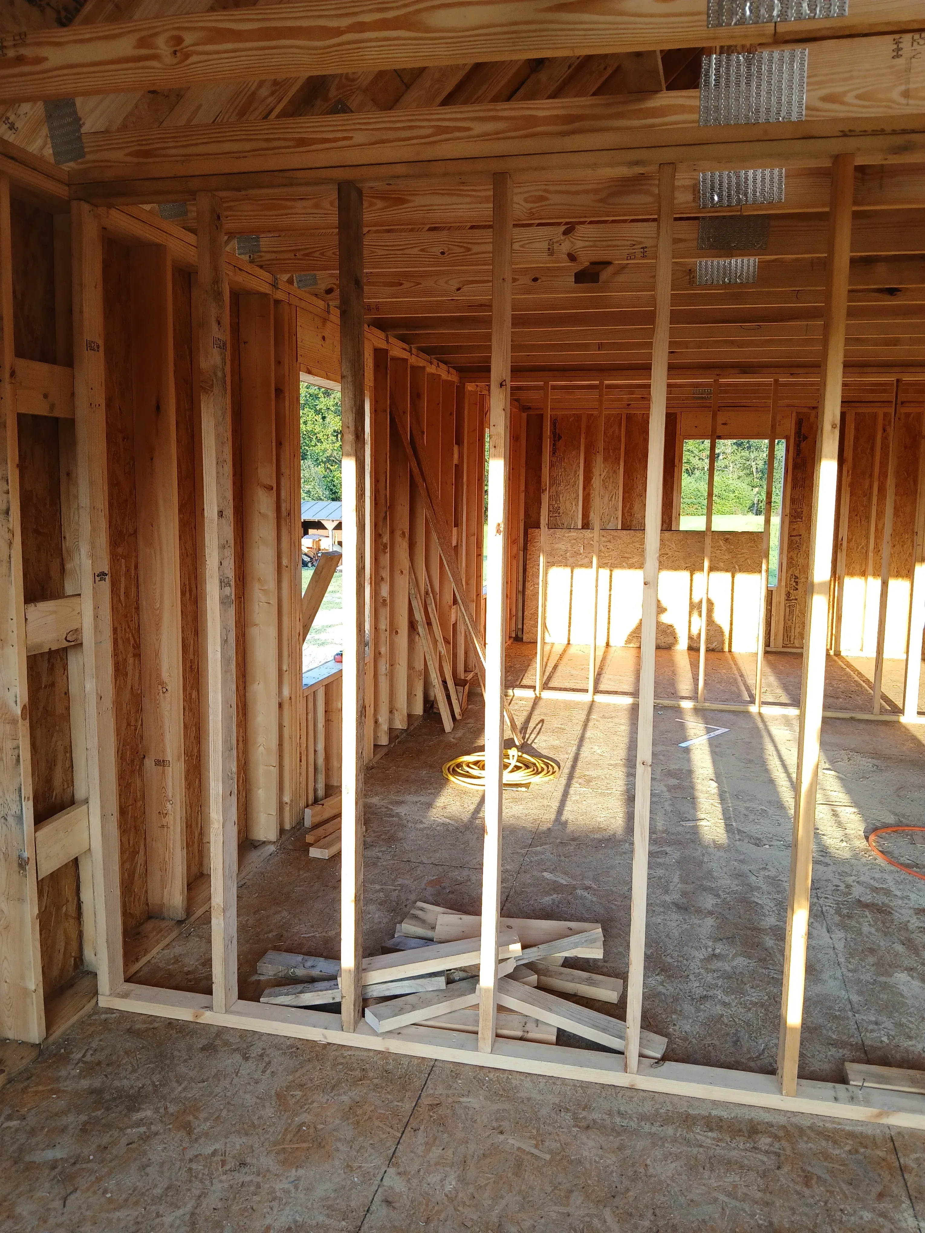 Wood framing interior with joists, beams, and window openings during construction