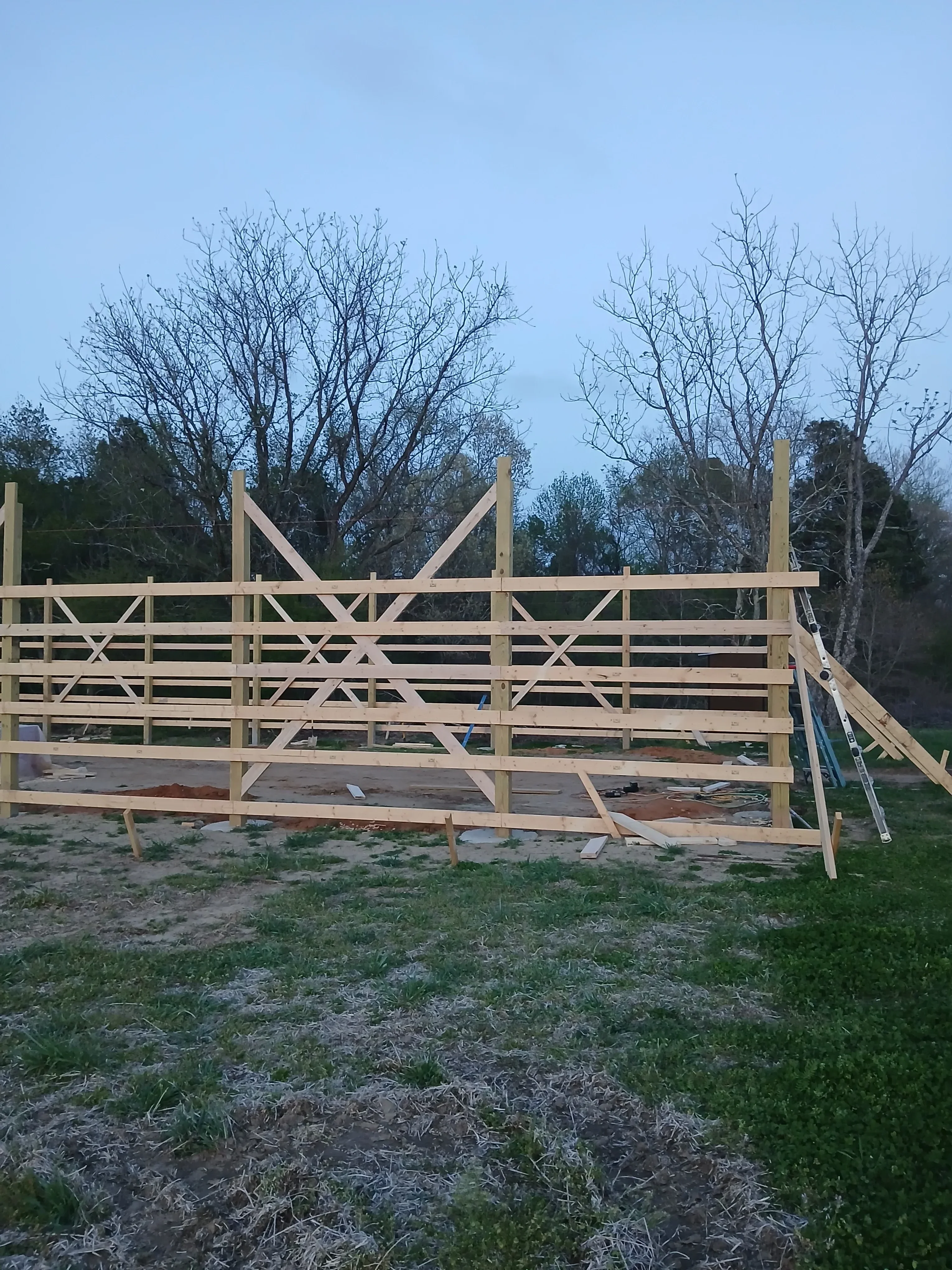 Wood frame addition with dimensional lumber, horizontal beams, and diagonal cross-bracing during construction phase