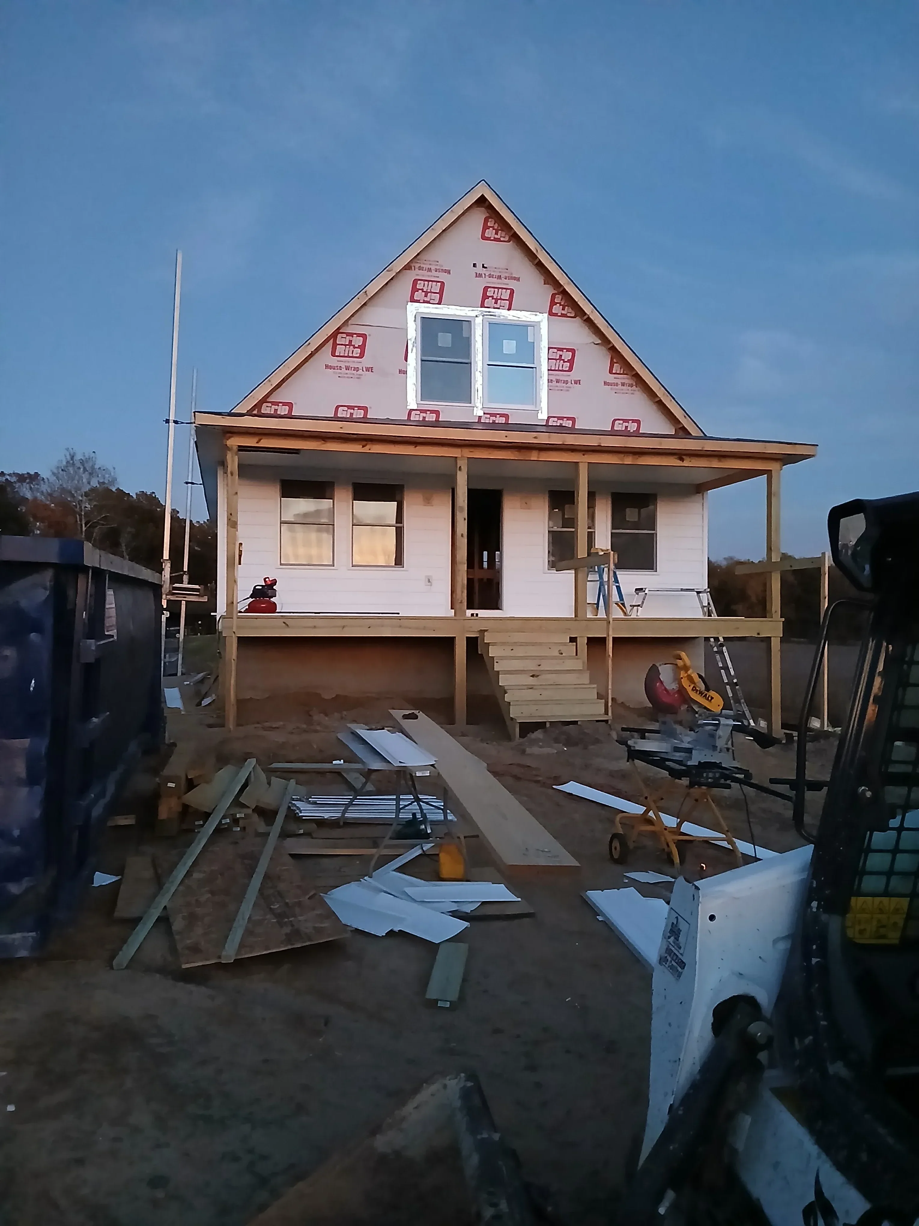 Wood-framed residential house with roof trusses, sheathing, and window openings during construction