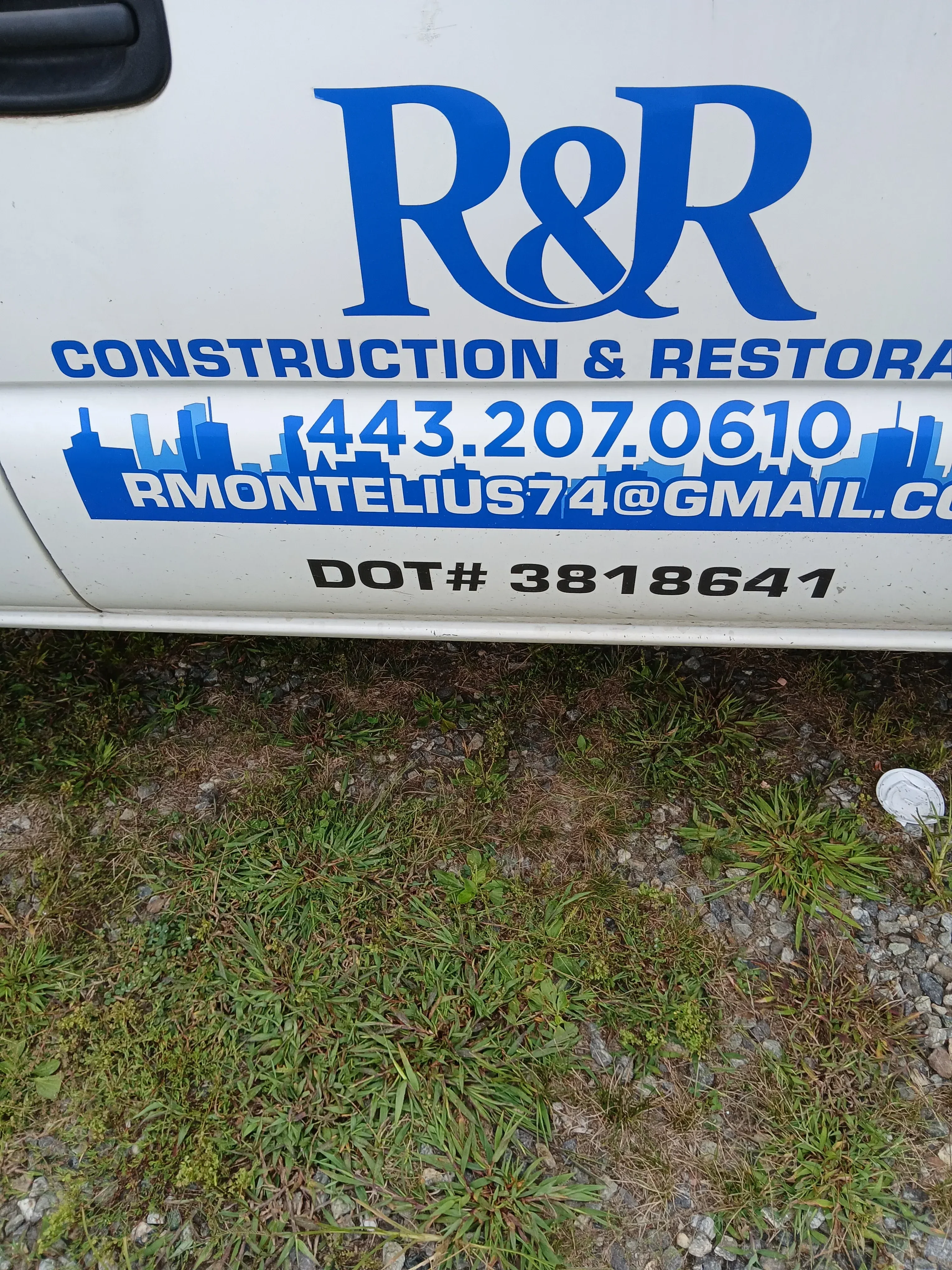 Blue and white construction company signage with vinyl lettering installed at job site