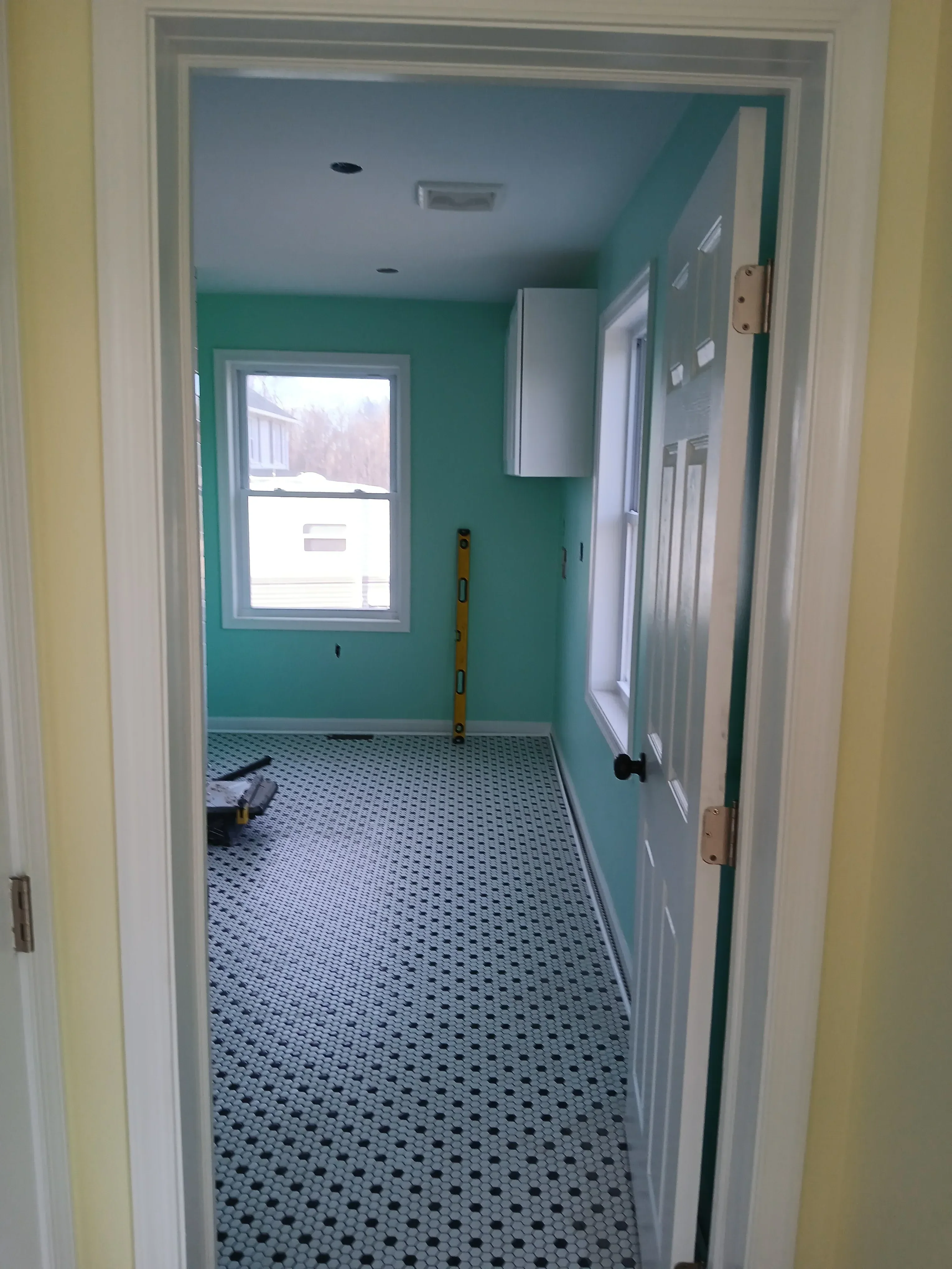Turquoise painted room with penny tile accent wall, recessed lighting, and new window installation