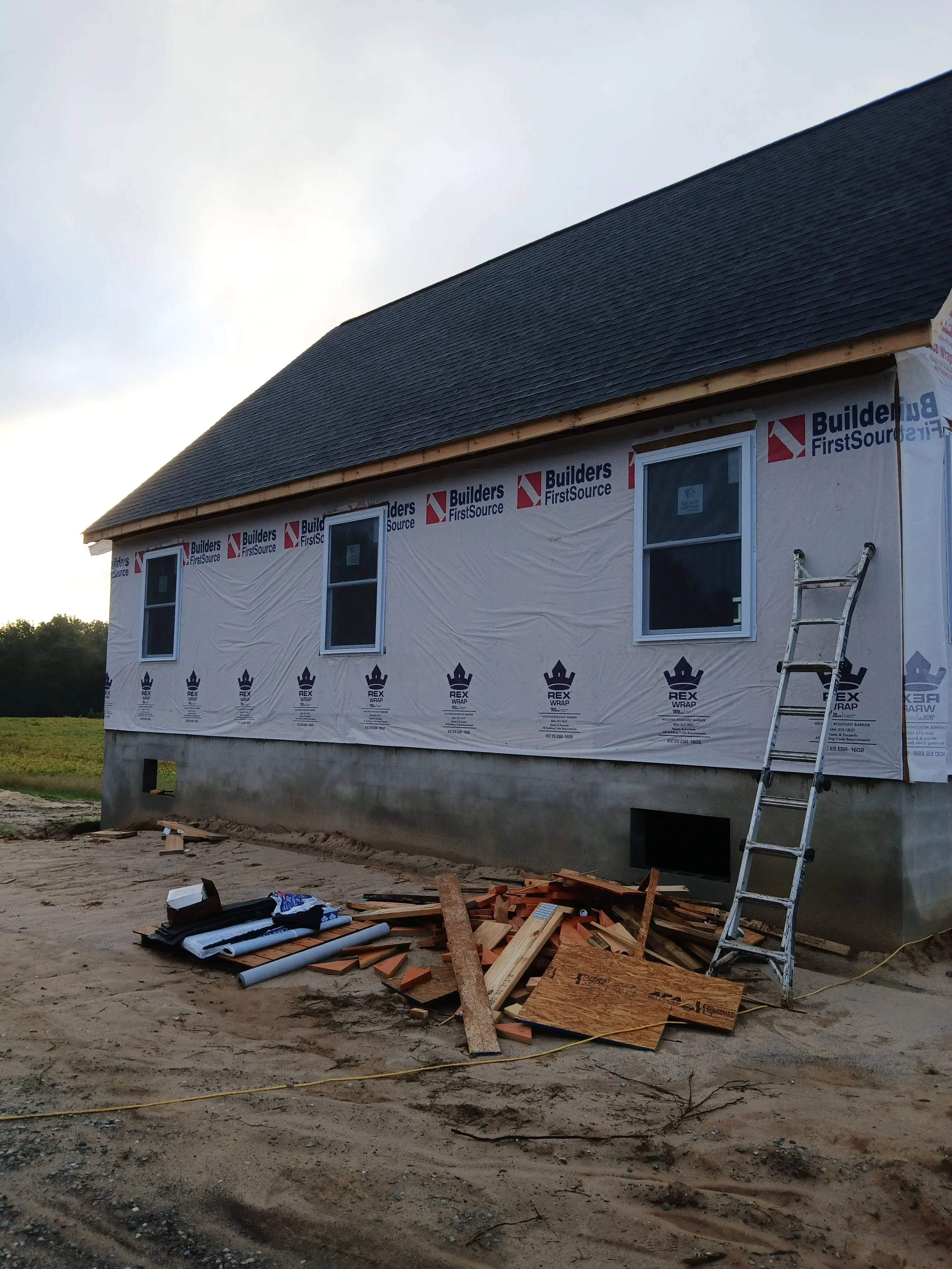 Corrugated metal siding, window installations, and construction staging on commercial building
